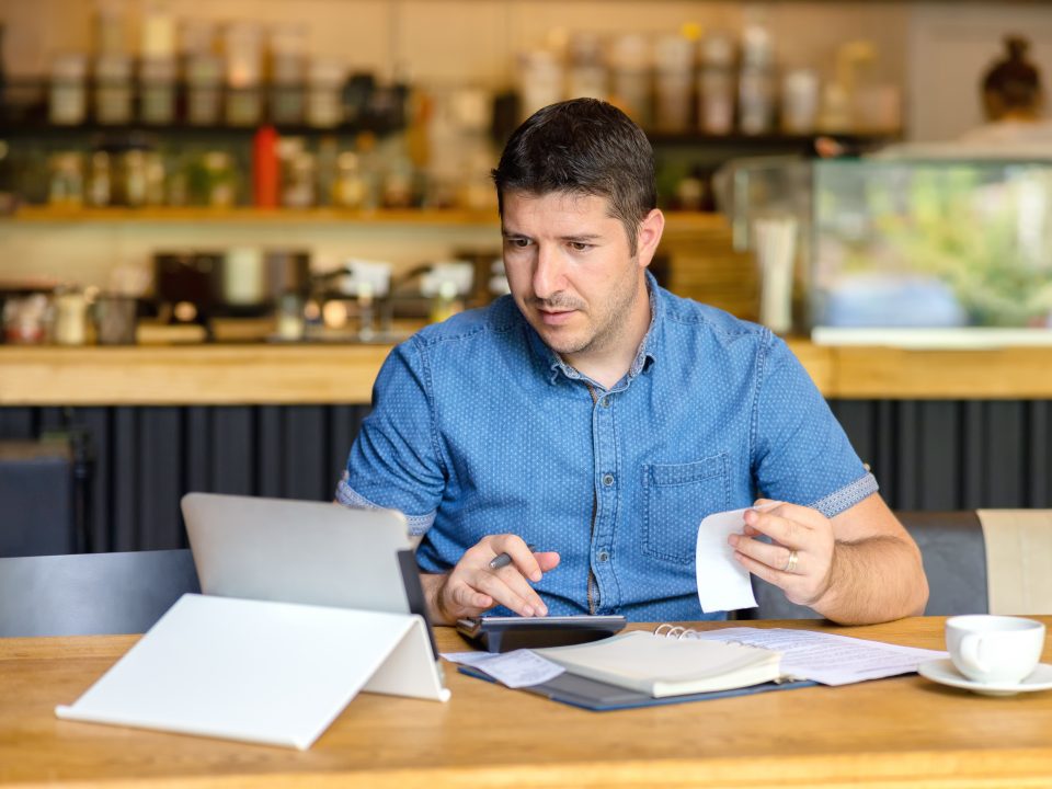 Benefit brokers assist small businesses with employee benefits and more, as depicted by this image of a businessman analyzing documents.