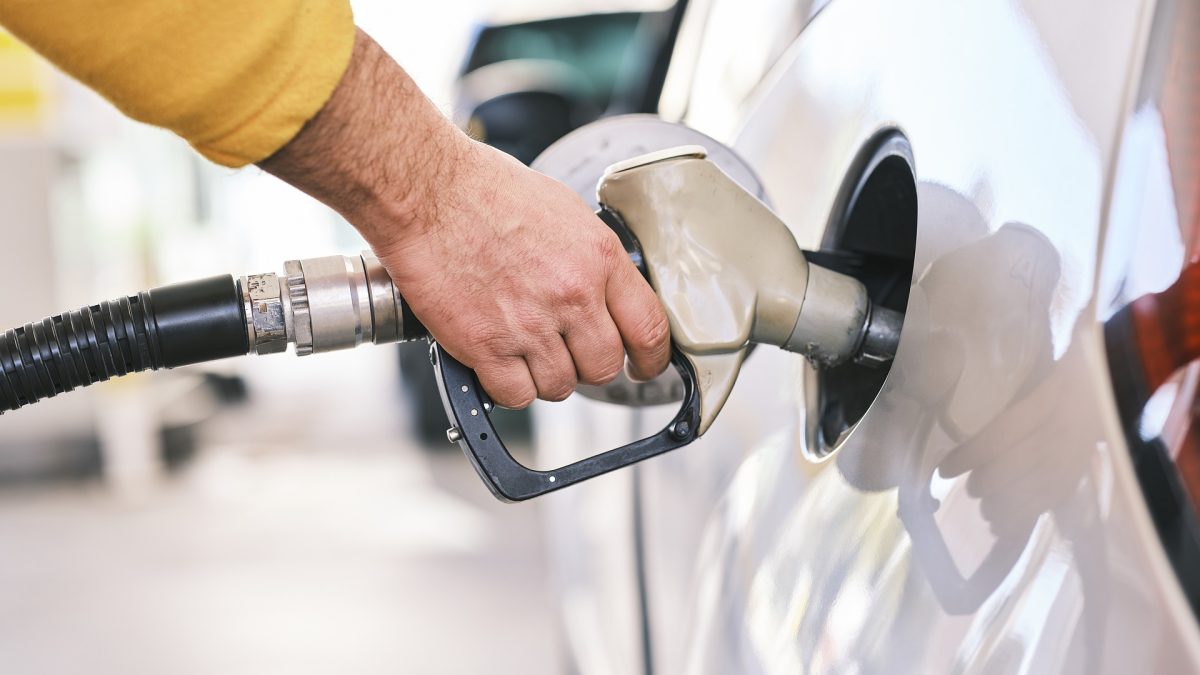 A man pumps gasoline into his vehicle. There are many ways to save on fuel costs.