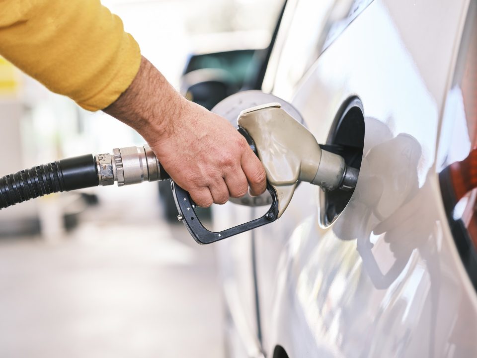 A man pumps gasoline into his vehicle. There are many ways to save on fuel costs.