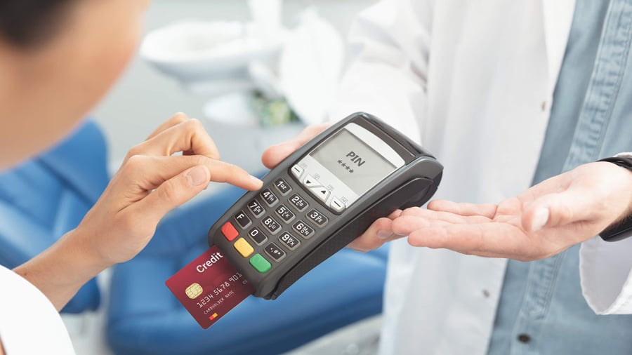 A credit card is used at a doctor's office. There are many benefits of paying cash for health care services even if you have insurance.