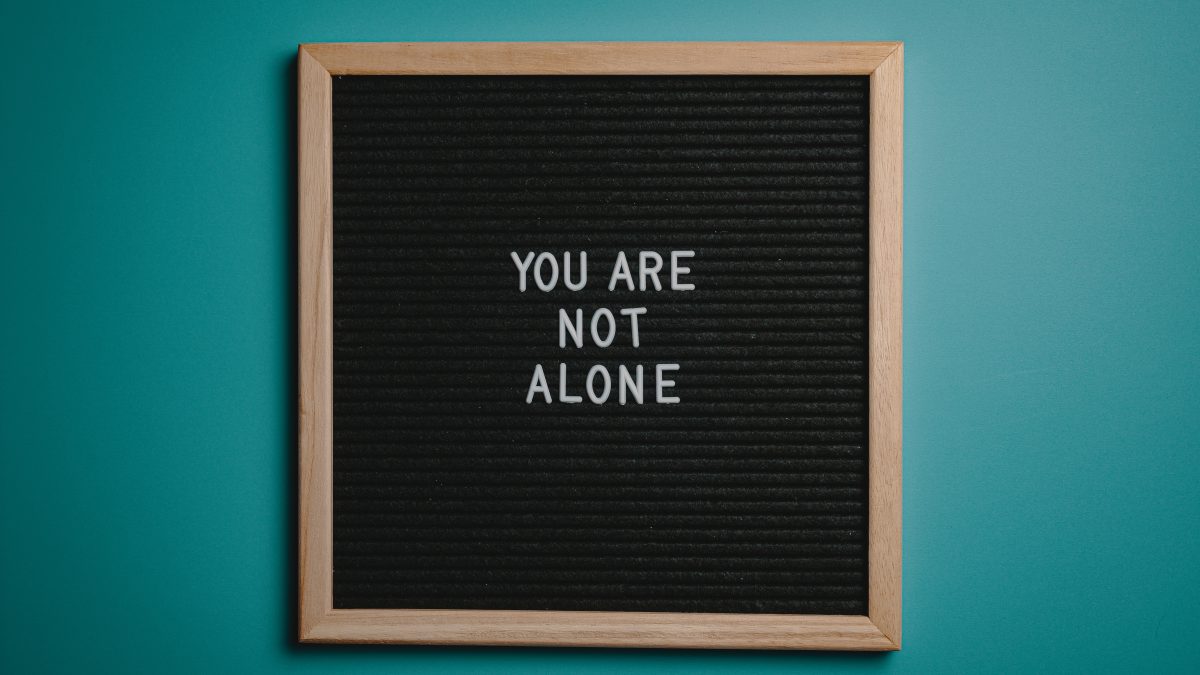 sign that says "you are not alone" to support mental health awareness.